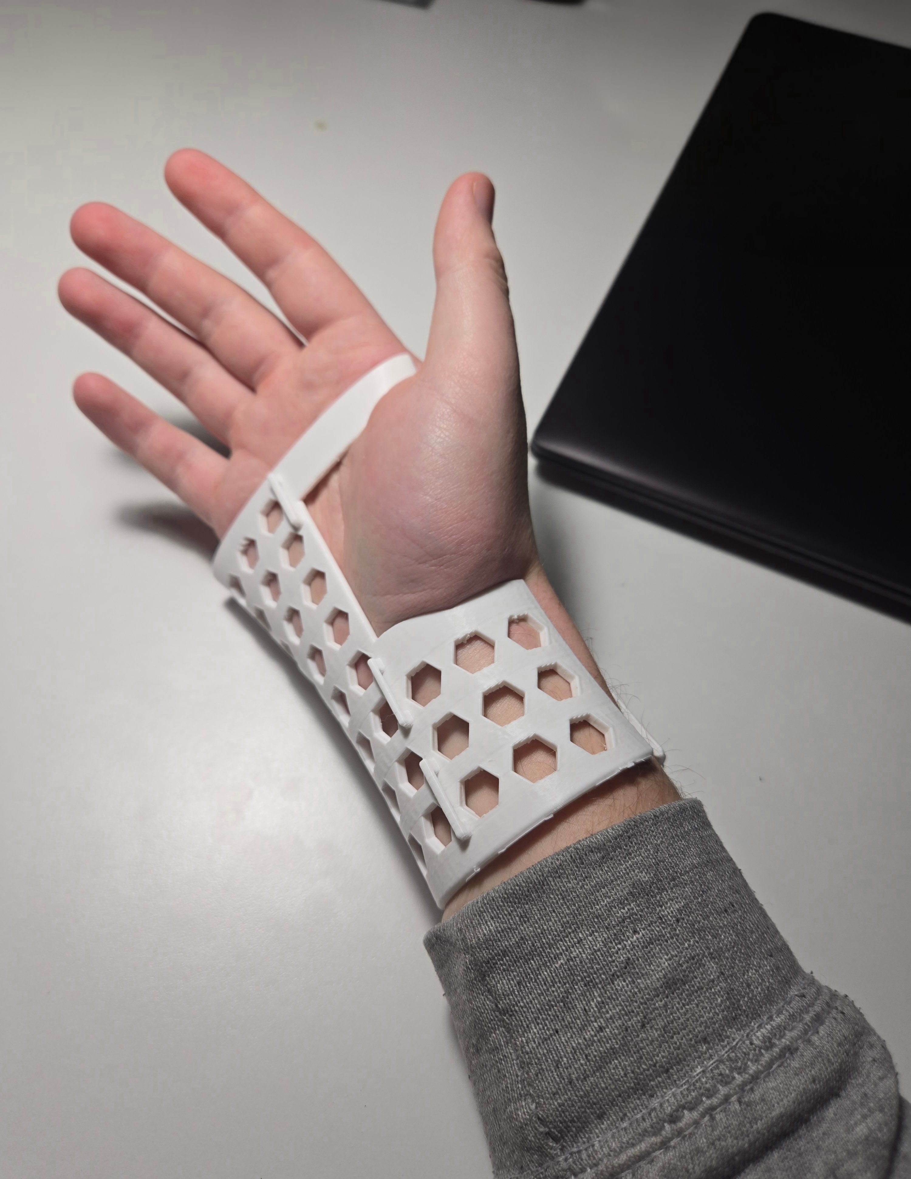 Early perforated brace prototype fit test on a hand